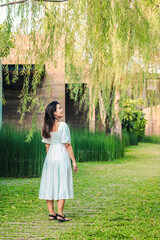 Beautiful Asian woman turn back and look the tree in garden