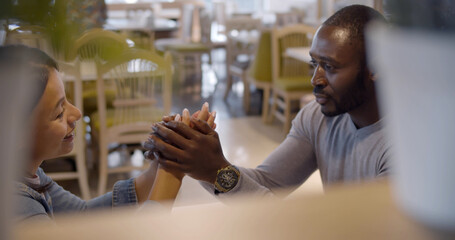 View behind shelf of african couple on date in cafe