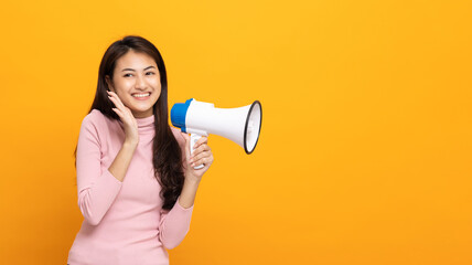 Shout out loud with megaphone. Young beautiful asian woman woman announces with a voice about...