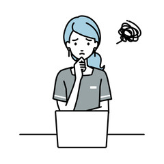 デスクで座ってPCを開いて困っているエステ店員の女性