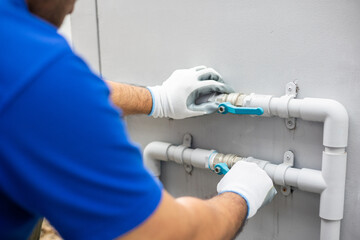 Male Plumber worker installation pipe system hand holding the water tap faucet. Plumbing checking service and repair.