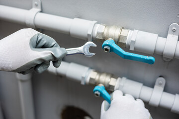 Male Plumber worker installation pipe system use wrench with the water tap. Plumbing checking...