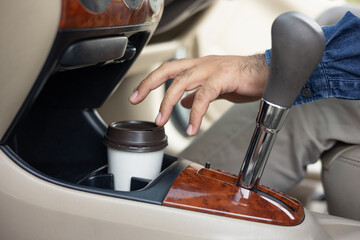 A cup of hot coffee put on the car console. Drinking coffee while travel by car.