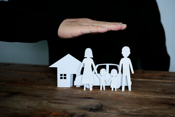 Fototapeta na wymiar Insurer protecting a family, a house and a car with his hands