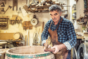 Wooden barrels manufacturer finished the building of another product with his own hands