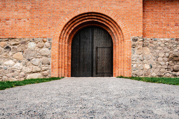 Fototapeta na wymiar Wooden door in the castle of red bricks.