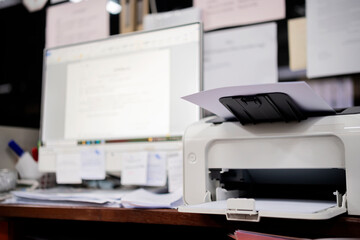 White printer in office with soft-focus and over light in the background.