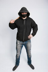 A masked bandit in a black hoodie, jeans and a bat on a white background.