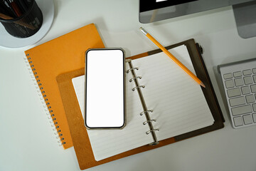 Mock up smart phone, notebook and coffee cup on white table.
