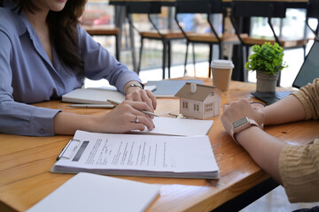 Cropped shot estate agent explaining contract details for her customer. Real estate and mortgage investment.