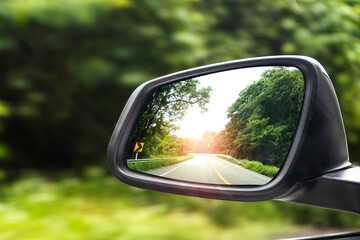 Landscape in the sideview mirror of a car , on road countryside.