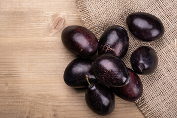 Fresh plums on a wooden table. 