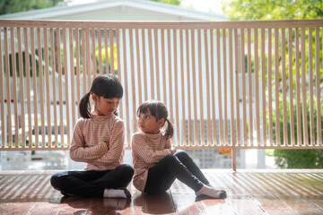 Upset siblings ignoring each other at home