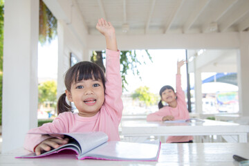 Little Asian girl at lesson in the classroom