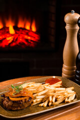 sliced aspic of beef tongue served with french fries on plate on a wooden table with mustard
