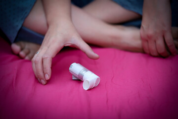 Woman using white asthma inhaler