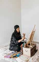 Filipino woman painting on easel 