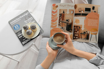 Young woman with cup of coffee reading magazine at home, closeup