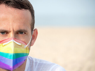 Face of man with face mask in the colours of the lgtb flag. Selective focus.