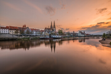 Fototapeta na wymiar Regensburg during sunset with Danube river and cathedral and stone bridge at golden hour, Germany