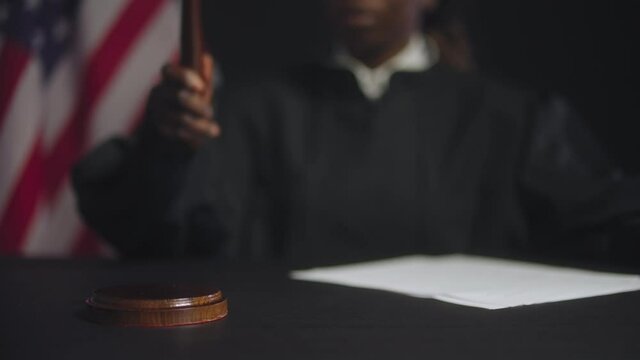 Black female judge striking gavel after final verdict, american justice system