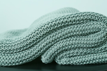 Knitted plaid on color background, closeup