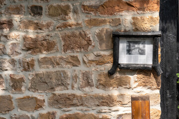 cartel antiguo de madera colocado sobre una pared de piedra en la casa de un pueblo