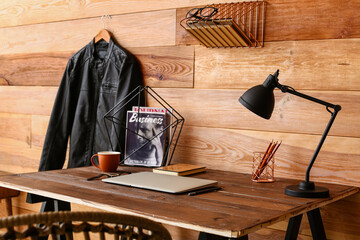Fototapeta na wymiar Modern workplace with laptop near wooden wall