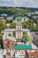 View of historical old city district of Lviv in cloudy morning, Ukraine. View of Dormition Church, Korniakt Tower. Early autumn. Old buildings and courtyards in historic Lviv
