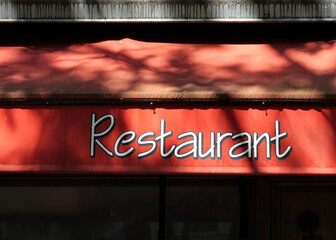 Restaurant. Lettrage blanc sur store rouge.