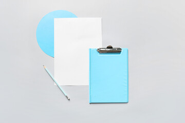 Composition with clipboard, sheet of paper and pencil on grey background