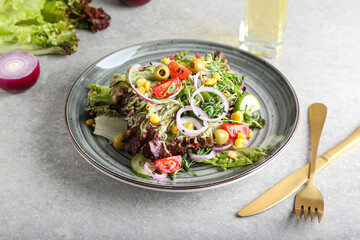 Plate of fresh salad with Lollo Rosso lettuce on table