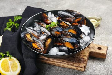 Plate with raw mussels on grunge background