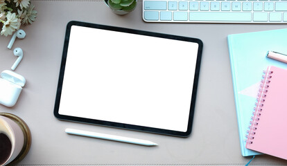 Top view mock up digital tablet with empty screen, stylus pen, earphone and coffee cup on white...