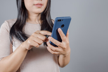 Portrait of Asian woman with long dark hair wears nude t-shirt finds out about her husband betrayal by spying on his phone, secretly check, pick up information