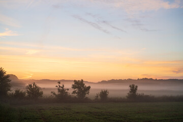 Fototapeta na wymiar Misty morning sunrise over the field