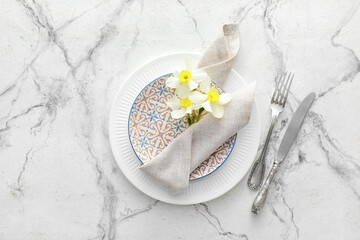 Fototapeta na wymiar Beautiful table setting with narcissus flowers on light background