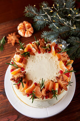 Festive Christmas cake decorated with fruits and rosemary.
