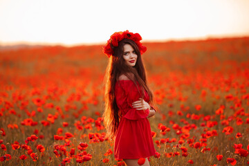 Beautiful brunette in red poppies field. Happy smiling teen girl portrait with wreath on head enjoying in poppy flowers nature background. Carefree woman.