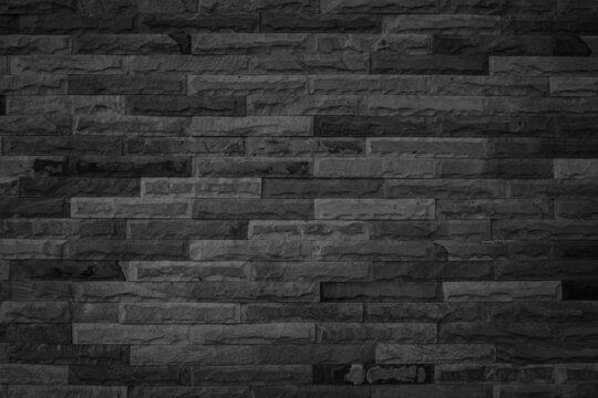 black brick wall for background and design. Dark sandstone wall texture and background with high resolution, pattern of stone brick wall.