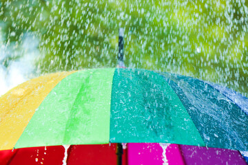 Open umbrella under falling rain drops outdoors