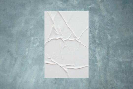 Blank white wheatpaste glued paper poster mockup on concrete wall background © Piman Khrutmuang