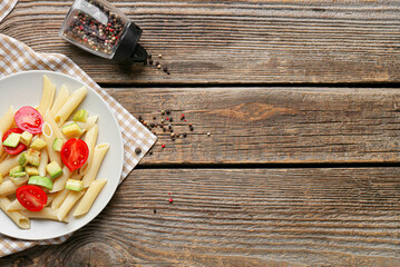 Plate of tasty pasta with vegetables on wooden background, closeup