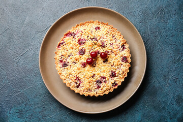 Plate with tasty cherry pie on dark background