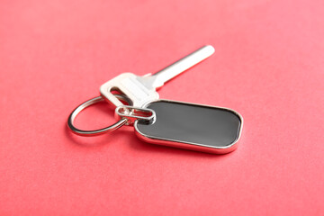 Key with stylish keychain on color background, closeup