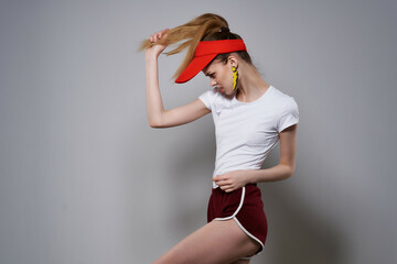 cheerful pretty woman in red cap posing summer yellow earrings