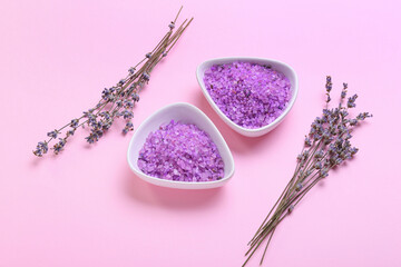 Obraz na płótnie Canvas Bowls with sea salt and lavender flowers on color background