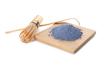 Wooden board with powdered blue matcha tea, chasen and chashaku on white background