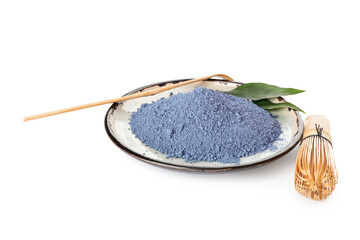 Plate of powdered blue matcha, chasen and chashaku tea on white background