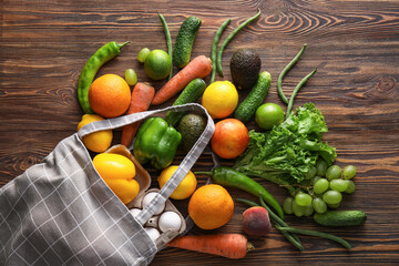 Eco bag with different products on wooden background
